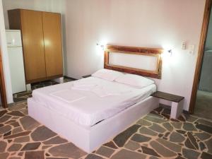 a bedroom with a white bed in a room at Arleta's Sunny Guesthouse in Prinos
