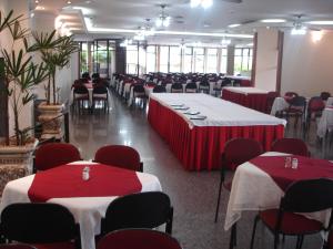 um salão de banquetes com mesas com toalhas de mesa vermelhas e brancas em Obeid Plaza Hotel em Bauru