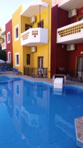 a large swimming pool in front of a building at Katerini Apartments Hotel in Platanes
