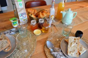 a wooden table with a plate of bread and glasses at Les Petites Maisons in Sotta