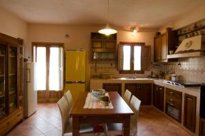 a kitchen with a table and chairs and a yellow refrigerator at Casa nel verde in Decollatura
