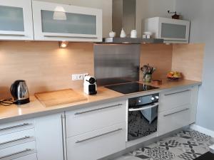 a kitchen with white cabinets and a stove top oven at Maison de ville style échoppe in Le Bouscat