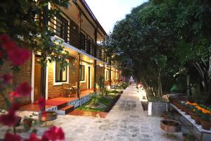 ulica domu z drzewami i kwiatami w obiekcie Nepal Cottage Resort w Katmandu