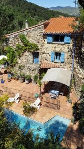 a house with a swimming pool next to a building at L'Oliveraie des 3 Mas in Saint-Michel-de-Llotes