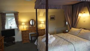 a bedroom with a bed and a dresser and a mirror at Wheelgate in Torver