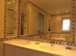 baño con 2 lavabos y espejo grande en Apartamentos Turisticos Vila Palmeira, en Lagos