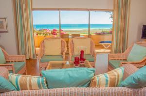 a living room with chairs and a table with a view of the ocean at Apartamentos Turisticos Vila Palmeira in Lagos