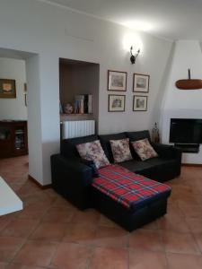 una sala de estar con un sofá negro con un Sidx rojo y corredizo en Bed & Breakfast Castello, en Padenghe sul Garda