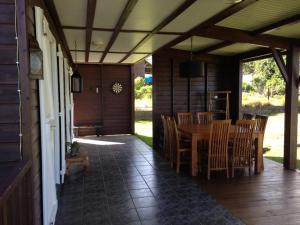 a porch with a wooden table and chairs on it at lesept in La Plaine des Cafres