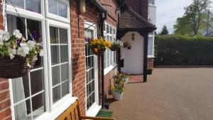 a brick building with flower pots on the side of it at Hampton Lodge En-Suite Rooms with Free Parking in Stratford-upon-Avon