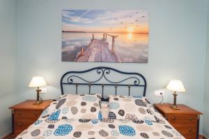 a bedroom with a bed and a picture of a pier at Lets Holidays RENOVATED APARTMENT NEAR BEACH in Tossa de Mar
