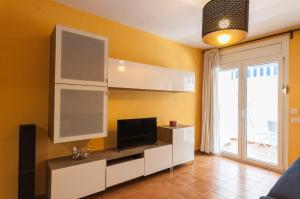 a living room with white cabinets and a television at Lets Holidays RENOVATED APARTMENT NEAR BEACH in Tossa de Mar