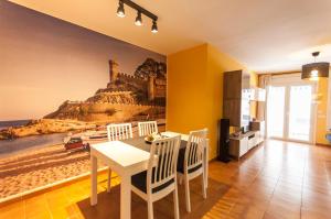 a dining room with a table and a painting of a beach at Lets Holidays RENOVATED APARTMENT NEAR BEACH in Tossa de Mar