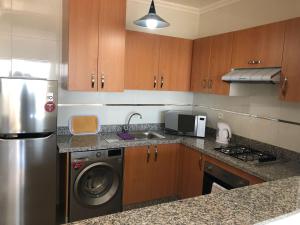 a kitchen with a stainless steel refrigerator and a dishwasher at Marina Golf Appart Chez Hicham in Asilah