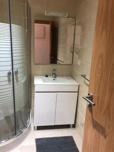 a bathroom with a sink and a shower and a mirror at Marina Golf Appart Chez Hicham in Asilah