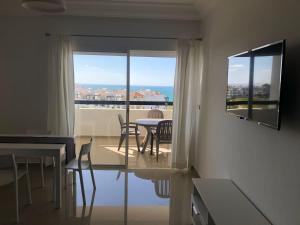 a living room with a table and chairs and a window at Marina Golf Appart Chez Hicham in Asilah