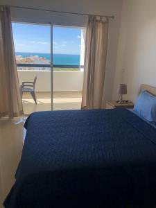 a bedroom with a bed and a view of the ocean at Marina Golf Appart Chez Hicham in Asilah