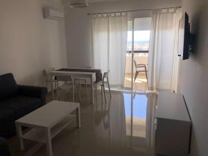 a living room with tables and chairs and a couch at Marina Golf Appart Chez Hicham in Asilah
