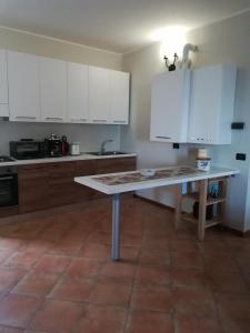a kitchen with white cabinets and a table in it at Bed & Breakfast Castello in Padenghe sul Garda