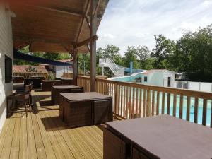 a deck with tables and chairs and a playground at Mobil home Domaine de Soulac in Soulac-sur-Mer