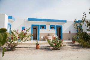 ein blau-weißes Haus mit einem Tisch und Stühlen in der Unterkunft Matina Studios in Kefalos