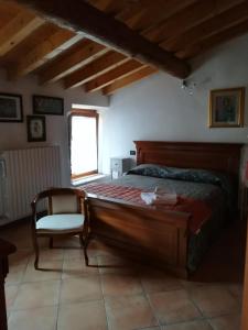 a bedroom with a bed and a chair and a window at Bed & Breakfast Castello in Padenghe sul Garda