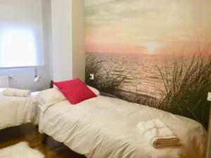 サリナスにあるSalimar 23の海の絵画が飾られた部屋のベッド2台