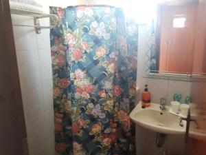 a bathroom with a shower curtain and a sink at Matina Studios in Kefalos