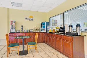 a restaurant with a counter and a table and chairs at Days Inn by Wyndham Norfolk Military Circle in Norfolk