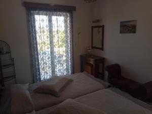ein Schlafzimmer mit einem Bett und einem großen Fenster in der Unterkunft Matina Studios in Kefalos