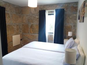 1 dormitorio con cama blanca y ventana en Casa de Mirão, en Baião