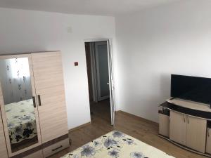 a room with a door and a room with a television at Apartament Bella in Jurilovca