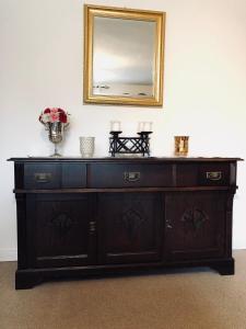 a wooden dresser with a mirror on a wall at Ferienwohnung Südel in Malente