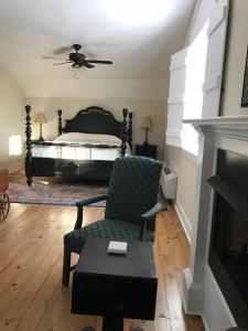 a living room with a bed and a chair at Canemount Plantation Inn in Westside