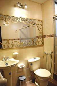 a bathroom with a toilet and a sink and a mirror at Hotel Golosone in Ambato