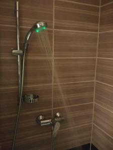 y baño con ducha con luz verde. en Pulse Jackquaters, en Budapest