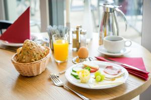 einen Tisch mit einem Teller Essen und einer Tasse Orangensaft in der Unterkunft HOF-SUITEN in Waren (Müritz)