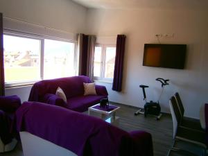 a living room with a purple couch and a tv at Apartment Willy in Komiža