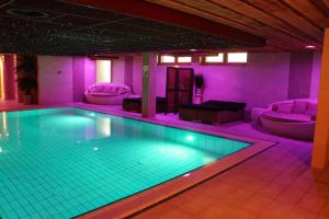 una piscina en una habitación con iluminación púrpura en Wellness Suites Dellewal en West-Terschelling