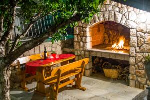 a table and chairs in front of a stone fireplace at Apartments Marin in Senj