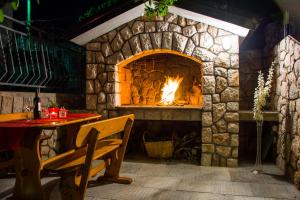 a stone fireplace with a table and a table and chair at Apartments Marin in Senj