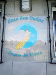 a sign on the side of a building with a surfboard at Casa Das Ondas - Praia Do Norte in Nazaré