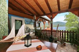 a house with a porch with a view of the water at Villa Barbara in Vrlika