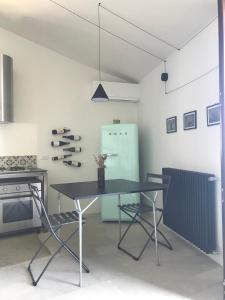 ein Esszimmer mit einem Tisch und einem Kühlschrank in der Unterkunft Casalmare in Cefalú