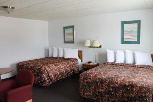 ein Hotelzimmer mit 2 Betten und einem roten Stuhl in der Unterkunft Budget Host Crestview Inn in Sault Ste. Marie