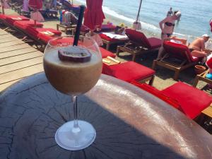 a drink in a glass sitting on a table next to the beach at Modern Seaview Beach Studio Limassol in Limassol