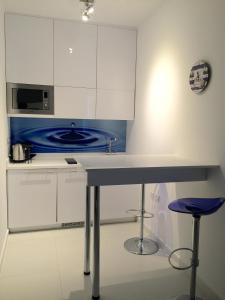 a kitchen with white cabinets and a blue stove at Modern Seaview Beach Studio Limassol in Limassol