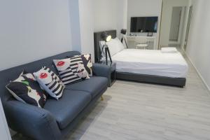 ein Wohnzimmer mit einem Sofa und einem Bett in der Unterkunft Comfy Studio 5 by ReCharge in Singapur