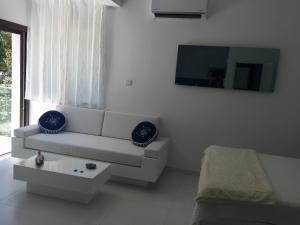 a white living room with a couch and a table at Modern Seaview Beach Studio Limassol in Limassol