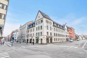 ein großes weißes Gebäude an einer Stadtstraße mit in der Unterkunft Forenom Serviced Apartments Oslo City Hall in Oslo